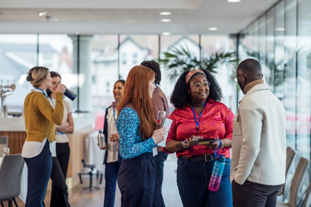 A mixed group of professionals mingling in a bright open office space