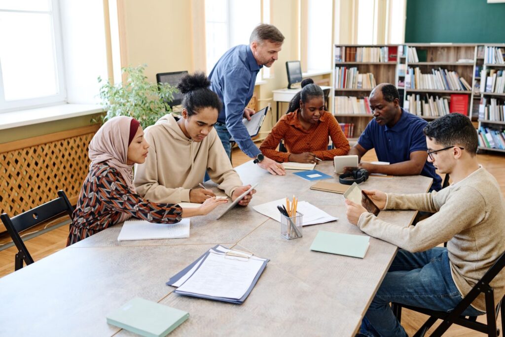 A mixed group of adults study around a table