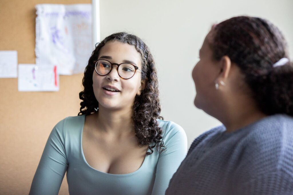 teenage girl in discussion with an older woman in a community building