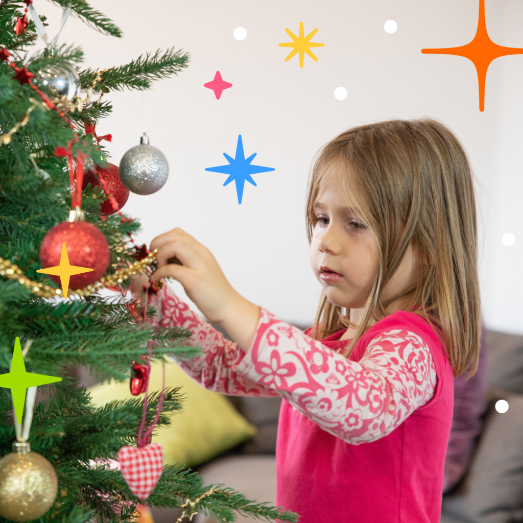 Young girl on her own putting decorations on Christmas tree